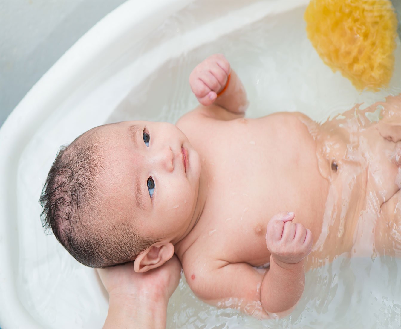 baño al bebé recién nacido en la bañera